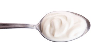 Metal kaşık beyaz arka plan üzerinde izole ekşi krema. Üstten Görünüm. Düz yatıyordu