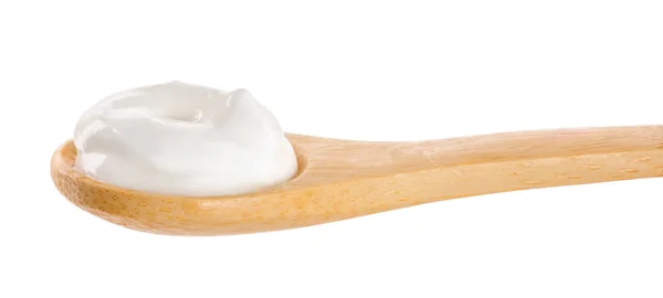 Kwaśna śmietana w drewnianej łyżce izolowana na białym tle — Zdjęcie stockowe