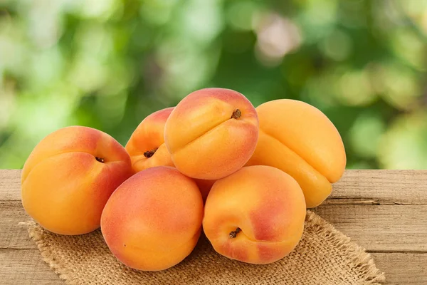 Apricot fruit on wooden table with blurred garden background. Clipping path — Stock Photo, Image