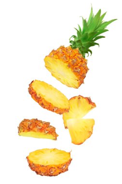 Düşen ananas dilimleri tam derinlikte beyaz arkaplanda izole edilmiş.