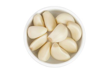 Beyaz arka planda izole edilmiş seramik kasede sarımsak karanfilleri. Üst Manzara. Düz yatıyordu