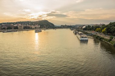 Güneş ışınları ve yumuşak renkleri ile günbatımı zamanında kentsel city scape Waterfront nehir ve gemi ile akşam
