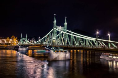 Waterfront şehir bölge ve Tuna Nehri Köprüsü ile Budapeşte gece kentsel görünümü