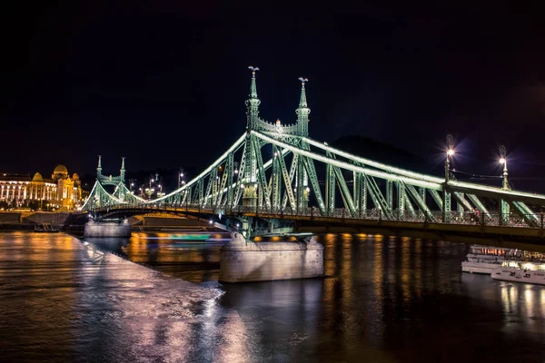 Waterfront şehir bölge ve Tuna Nehri Köprüsü ile Budapeşte gece kentsel görünümü