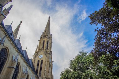 parlak yaz gününde mavi gökyüzü arka planda aşağıda eski ortaçağ Gotik kilise cephesi