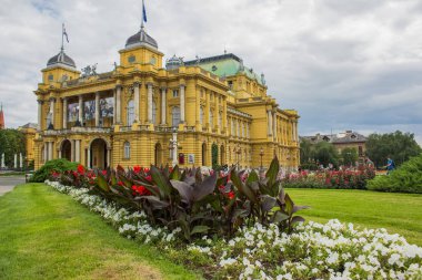 ön planda renkli çiçek yatağı ile Opera Evi Bina mimarisi sarı cephe