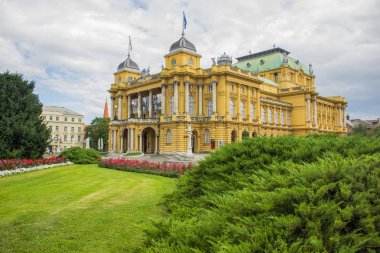 ön planda renkli çiçek yatağı ile Opera Evi Bina mimarisi sarı cephe