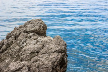 deniz kenarı bölgesi ve yaz aylarında taşlar yakın küçük dalgalar ile su yüzeyi sakin çevre kavramı renkli parlak gün zaman ve kopya veya metin için boş alan