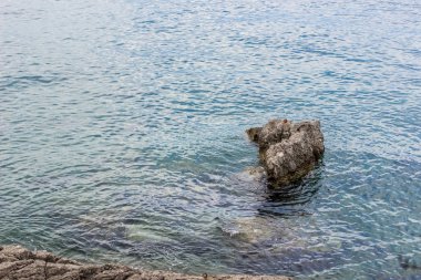deniz kenarı bölgesi ve yaz aylarında taşlar yakın küçük dalgalar ile su yüzeyi sakin çevre kavramı renkli parlak gün zaman ve kopya veya metin için boş alan