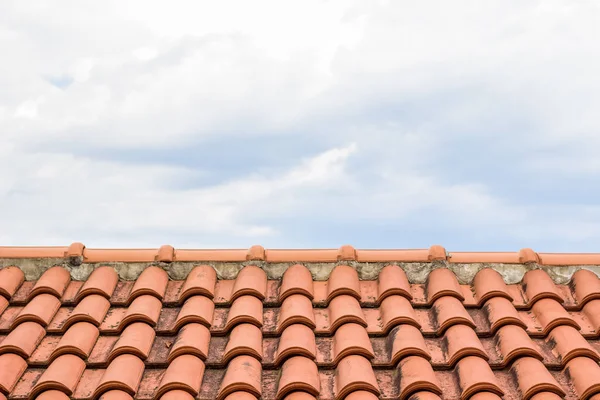 帯状疱疹の赤い家の屋根の前景のテクスチャとコピーまたはテキストのための空のスペースと灰色の曇り空の背景の概念 — ストック写真