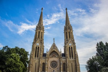 Aşağıdan park açık mavi gökyüzü bulut arka plan ile yaz parlak renkli günde bina eski ortaçağ Gotik kilise mimari cephe