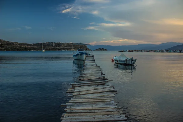 third world Asian country harbor handmade wooden pier with fishing boat in evening twilight calming time after sunset