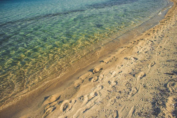 夏休みは 地中海のウォーターフロントの海岸ラインと柔らかい青い透明な水に沿って歩いた後 表面に人間の足のプリントと空の砂浜の美しい風景のアイデアを落ち着かせる — ストック写真