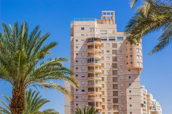 common high apartment building in south Middle East region near Red sea park outdoor summer space with blue sky and palm trees, good live concept, copy space