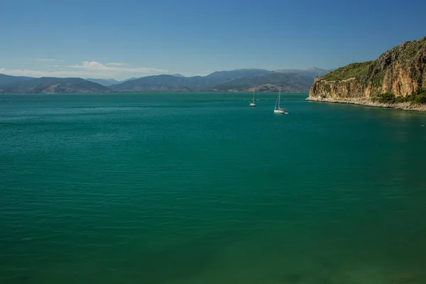 穏やかな水面にクルーズ船と南ギリシャの海岸線の山に囲まれた地中海湾 テキストのための空のコピースペースを持つ観光代理店のための夏休みの概念 — ストック写真