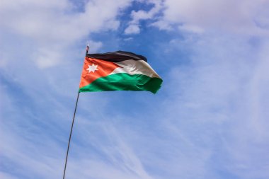 Bulutlar arka plan Orta Doğu ülke ve siyasi kavramı ile mavi gökyüzünde rüzgarda gelişen Ürdün bayrağı 