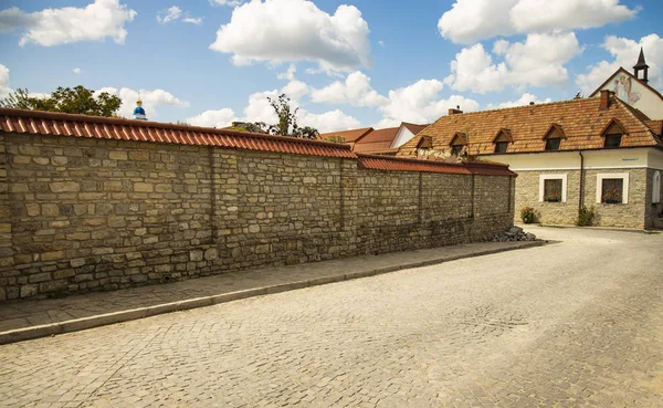 Ukrainian old city back street alley way with stone wall paves road and monastery small building in colorful day time and clear weather