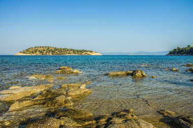 ufukta ada arka plan görünümü ile huzurlu sahne manzara deniz taş sahil şeridi resim 