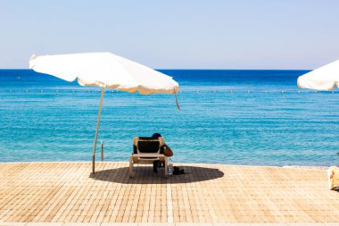 yaz sezonu tatil zaman dinlenme insan ile salon yakınında ahşap güverte zemin ve beyaz şemsiye ile tatil pastoral sahil şeridi, metin için boş alan ile duvar kağıdı arka plan resmi