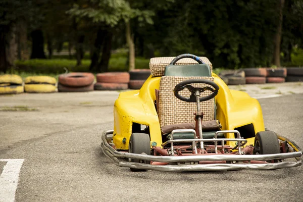 Leere Gelbe Kartbolide Auf Asphaltpiste Eingezäunt Durch Reifen Hintergrund — Stockfoto