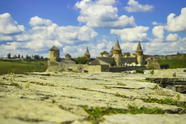 travel destination poster photography of European castle unfocused shape background and concrete old paved road foreground in clear colorful summer time