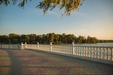 akşam günbatımı huzurlu yumuşak renkler zaman nehir rıhtım beyaz mermer çit ve ada arka plan Avrupa parkı Şehir meydanı yürüyüş ve gezinti alanı 