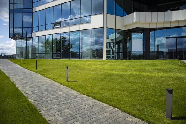 modern ekolojik peyzaj şehir görünümü ofis merkezi cam dış cephe ve asfalt yol ile yeşil çayır avlusu 