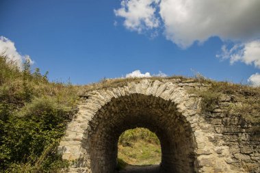 Mavi gökyüzü beyaz bulutlar arka plan ile Büyük Britanya yeşil tepeler kırsal açık alan antik taş kemer tünel binası, kopya alan