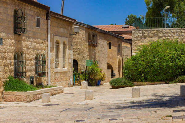 Старый квартал Иерусалима без людей с каменной асфальтированной дорогой и небольшими одноэтажными зданиями
