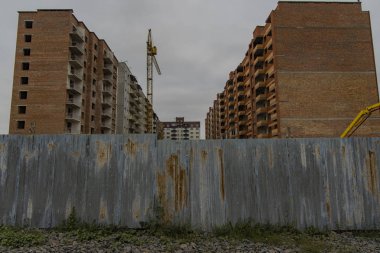 Rusya 'dan inşaat iskeleti fotoğrafçılığı gri depresyon renkleri sonbahar bulutlu yağmurlu hava zamanı, metal paslı çit önplanı 