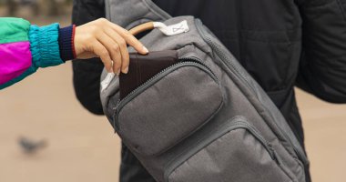 Cep hırsızı el, cüzdan parasını gri çanta konseptinden suç fotoğrafçılığından alır. 