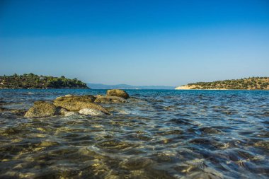 Kuzey Avrupa soğuk ada manzaralı deniz körfezi kayalık kaya kıyı şeridi önü ve ana kara kıyısı arka planı 
