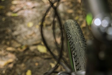 Fren sistemi hortumları çerçevesinde bisiklet tekerleği lastiği ve zemin kahverengi bokeh arka planında araç leşi 