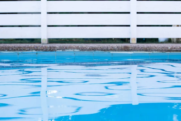 シンプルな壁紙パターンビュー庭屋外スペーススイミングプール青い水面前景と白い庭木製のデッキフェンスあなたのテキストのための空のコピースペースと背景画像 — ストック写真