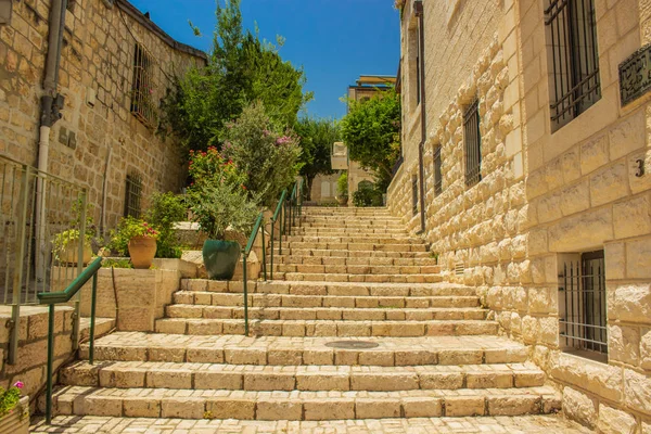 Eastern colorful back street stairs alley way between ancient stone buildings in summer warm season clear weather time