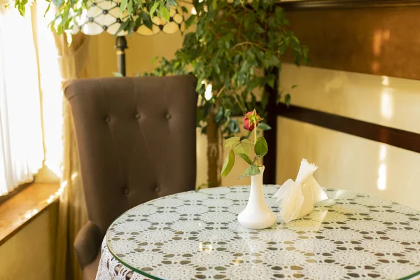 cozy cafe room interior environment table with chair flower vase and napkins under bright sun light yellow color