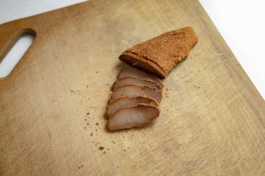 Basturma Ermeni mutfağı ahşap kesim tahtasındaki at tuzlu et dilimlerinden lezzetli yemekler, beyaz stüdyo arka planı ve metin için boş kopya alanı. 