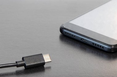 Bu süre için iletişim için telefon şarj mobil aygıtı sosyal uzaklık, ofis tablosu gri yüzey alanı kopya veya metin için basit arkaplan alanı