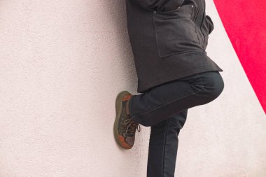 rustik şehir pantolonları ve ayakkabıları giyiyorlar erkek kumaş tarzı insan fotoğrafçılığı duvarın yanında durmuyor arka plan desenli nötr bej ve pembe renkli ve metin için boş kopya alanı var.