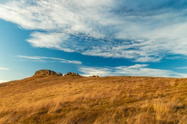 Sonbahar açık hava zamanı kayalık dağlar manzaralı çimen manzaralı arazi önü ve mavi gökyüzü beyaz bulutlu arka plan uzayı