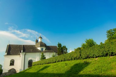 Manastır kilisesi Doğu Avrupa mimarisi yaz manzarası manzarası yeşil çayır ve mavi gökyüzü arka plan açık Haziran günü