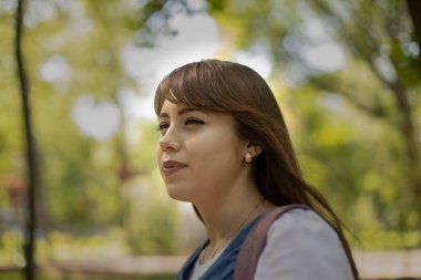 Avrupalı beyaz kız portresi şüphe sakin duygu bulanık park manzaralı arka plan görüntüsü