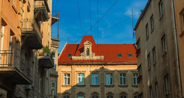 Eastern Europe old city street landmark urban view architecture exterior facade red roof building narrow alley way foreshortening from below with blue sky background in clear weather day time