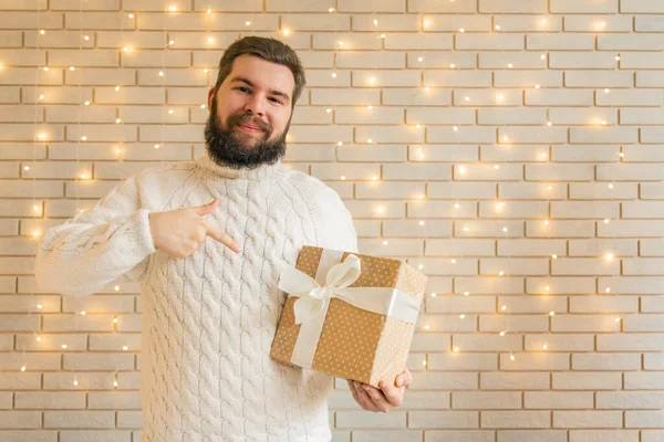 大胡子男子笑着摆设圣诞佳节礼物12月墙纸广告概念白色的清洁房间加花环照明 — 图库照片