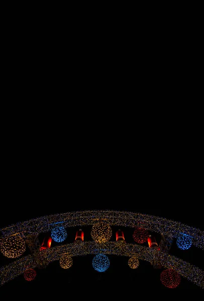 黒の背景にクリスマスの夜の通りの装飾ガーランド照明ランプ屋外スペース垂直画像の壁紙パターン形式あなたのテキストのための空のコピースペースをここに — ストック写真
