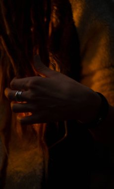 Pagan geleneği, kadınların el ve parmaklarının sıcak sarı lamba içinde soyut görüntüsü karanlık çevre mekanında Cadılar Bayramı tatillerinde sonbahar dönemi odaklanmış konsept fotoğrafçılığı