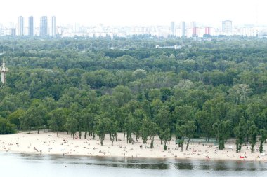 Asya 'nın kirli şehrinin dumanlı manzarası nehir parkı yeşil bölgesi boyunca sahil şeridi boyunca uzanan kalabalığın manzarası panorama ufuk arkaplan gökdelenleri şehir yaşam bölgesi