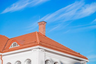 yazlık ev beyaz duvar ön cephe çerçeve ve çatı kırmızı fayans baca tuğla boru şekli canlı mavi gökyüzü arka plan uzay