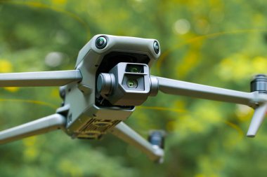 Uçan İHA hareket bulanık pervane kanatları yakın korpus ve vimbal kamera fotoğrafçılık ve doğal odaklanmamış arka plan lens sistemi ile