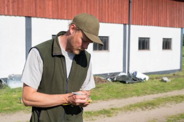 Adam bahçesiyle ilgilenirken notlar alıyor.